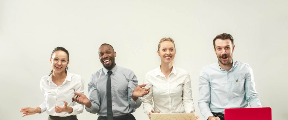 young-happy-african-and-caucasian-men-and-women-sitting-at-office-and-working-on-laptops